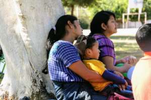 Participating mothers look on with their children