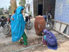 Women Taking water from container placed out of sc