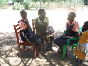 PLA Staff Susan talks to 2 beneficiaries in Lira