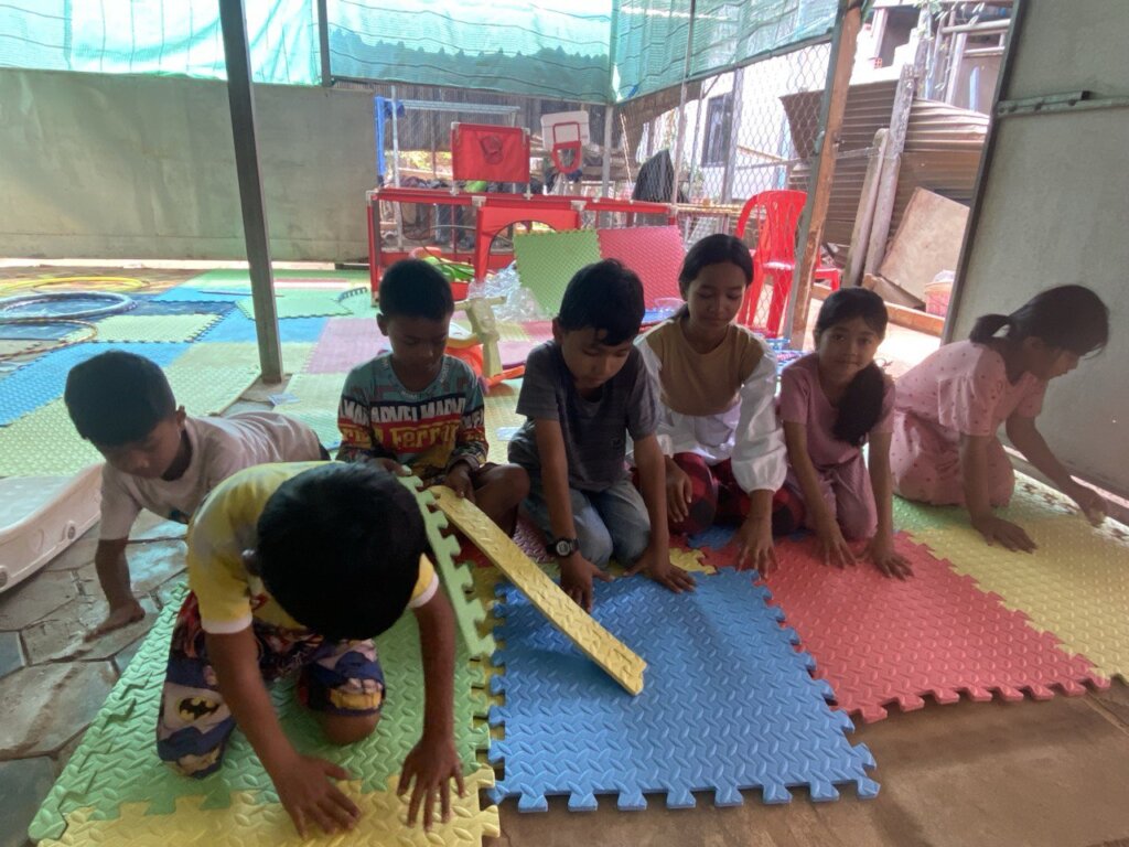 Children help to build up and connect the carpets