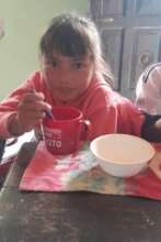 Girl from Piruaj Bajo eating a snack