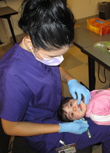 A young patient getting her teeth checked
