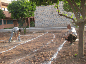 Mohamed, r, overseeing the marking of gravel paths