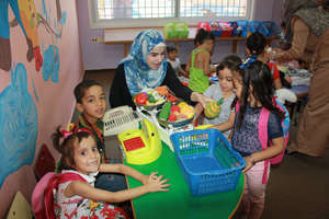 Volunteer Fatima helps facilitate imaginative play
