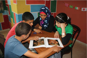 Volunteer Maysoon practices reading with students.