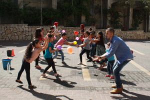 Teacher Ahmad plays balloon toss with his students