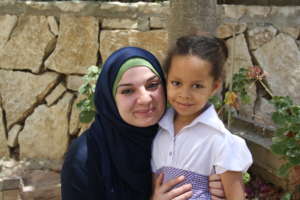 Malak, 5 years old, with her teacher Fawz.