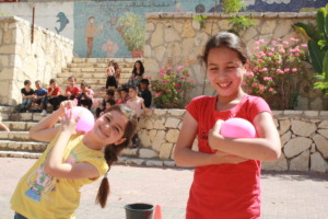 Students Hoor &Yasmine smile with their balloons.