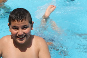 A student smiles as another dives below the water.