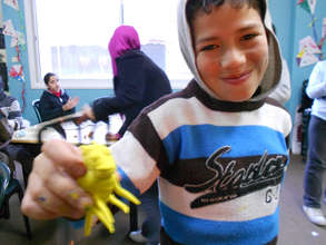 A proud student makes a clay animal in art class