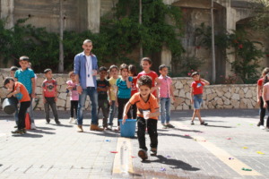 Student Zain smiles as he runs to fill the bottle.