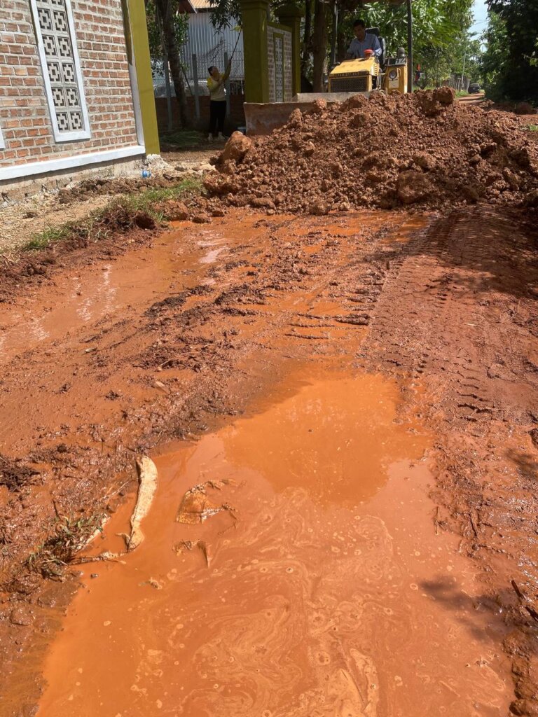 Bulldozer makes red soil and stone on broken roads
