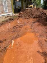 Bulldozer makes red soil and stone on broken roads