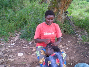 Rhema braiding a customer's hair