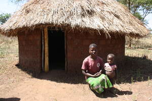 Scovia and son Isaac with the hut from money saved
