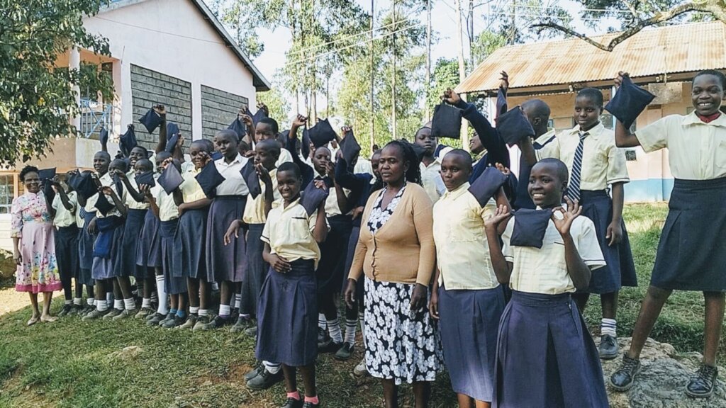 Girls pose with donated reusable sanitary pads.