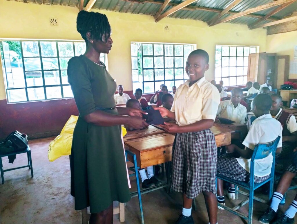 A schoolgirl receives reusable sanitary pads.