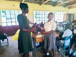 A schoolgirl receives reusable sanitary pads.