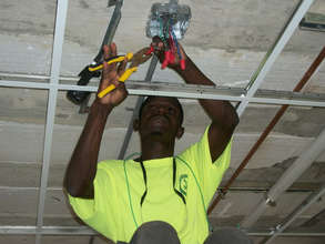 A Haitian electrician caps the ends of wires