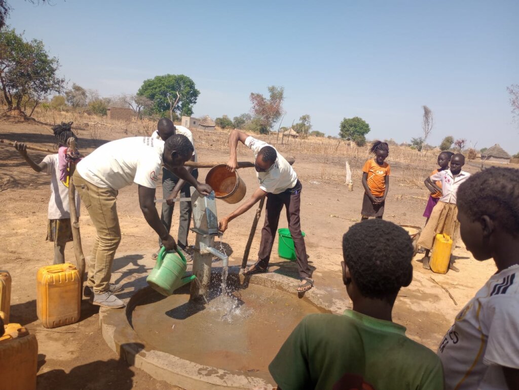Committee members demonstrate wells for residents