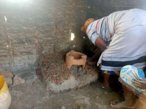 A woman constructing a clean cookstove