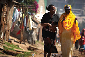 Jane Otai, left, speaks with woman in Nairobi
