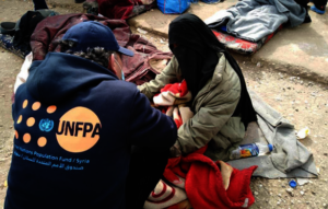 A UNFPA staff member speaking with a mother.