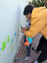 Painting hand prints on the wall outside