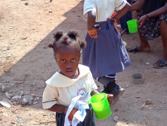 her holding cup of porridge
