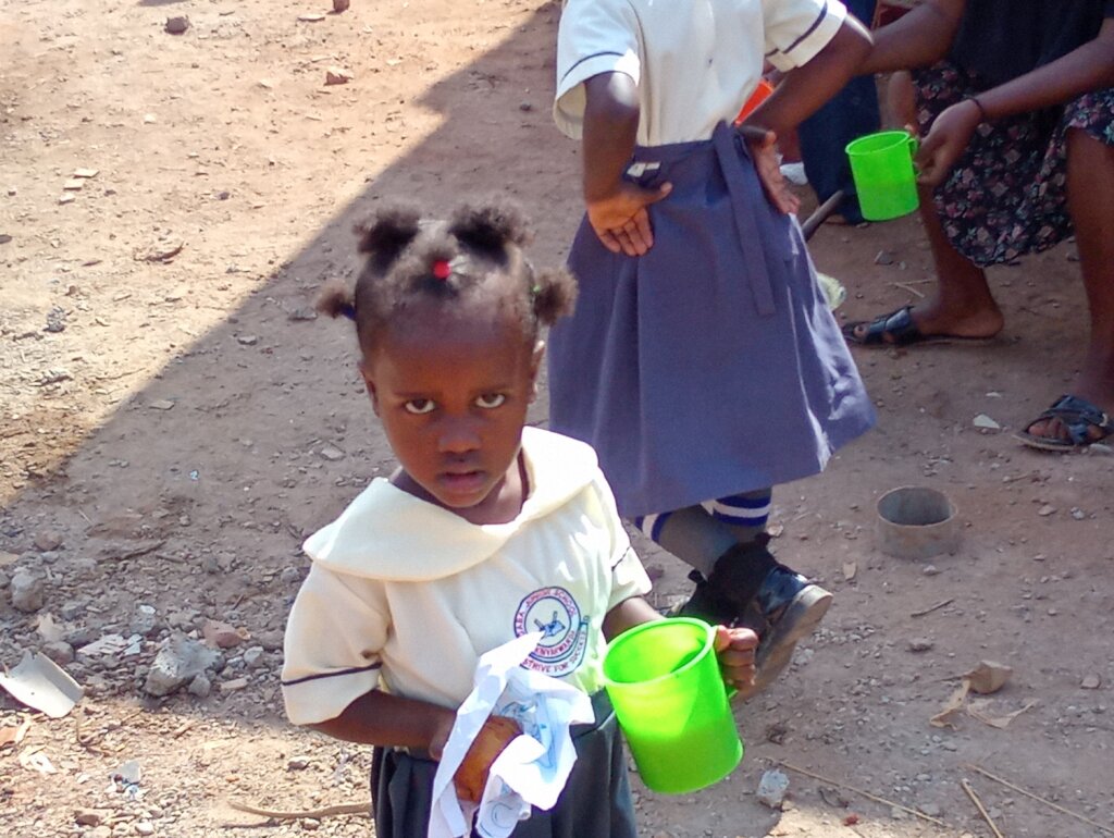 her holding cup of porridge