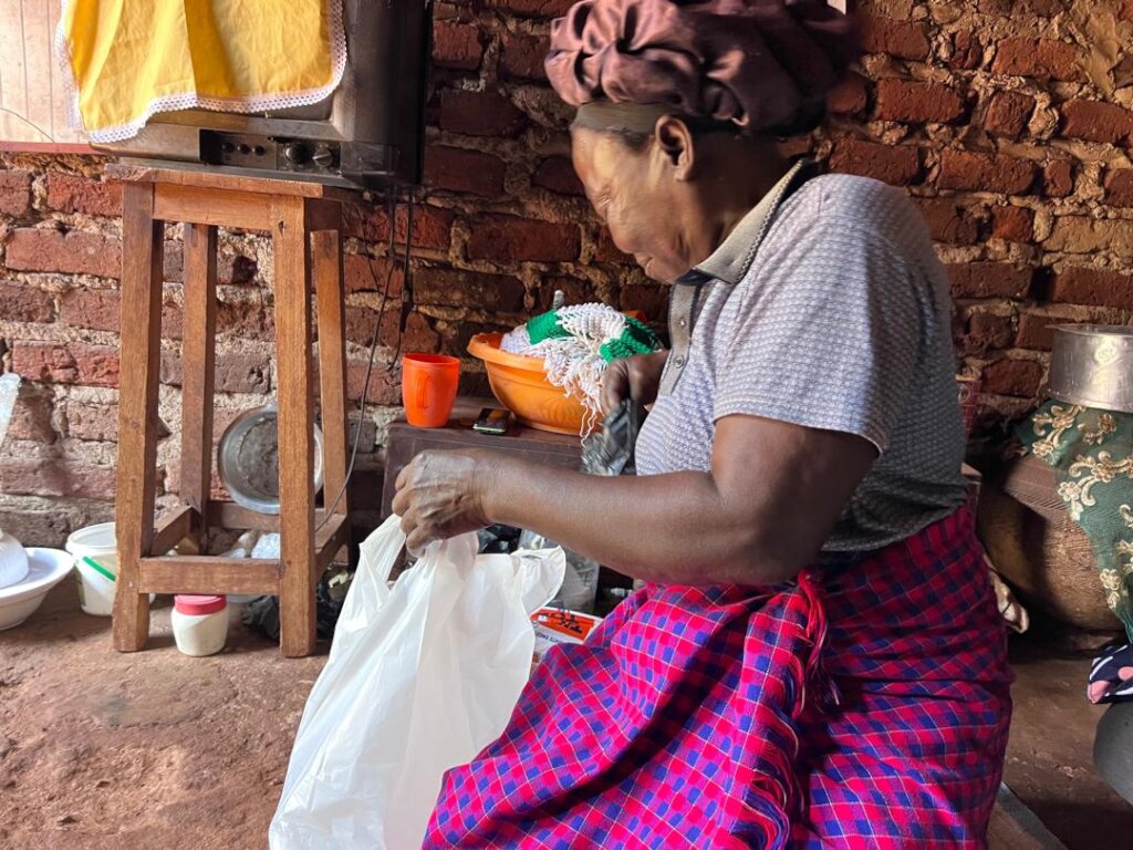 A widow in Namulesa Village checking her hamper