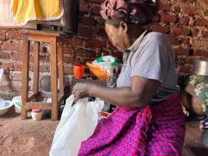 A widow in Namulesa Village checking her hamper
