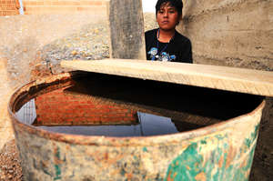 Rain water is stored in open barrels for washing