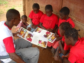 Camp facilitator reading with students