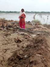 "A Mother Stands Where Her Home Fell"