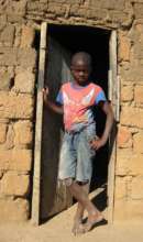 Young boy in the doorway of his home