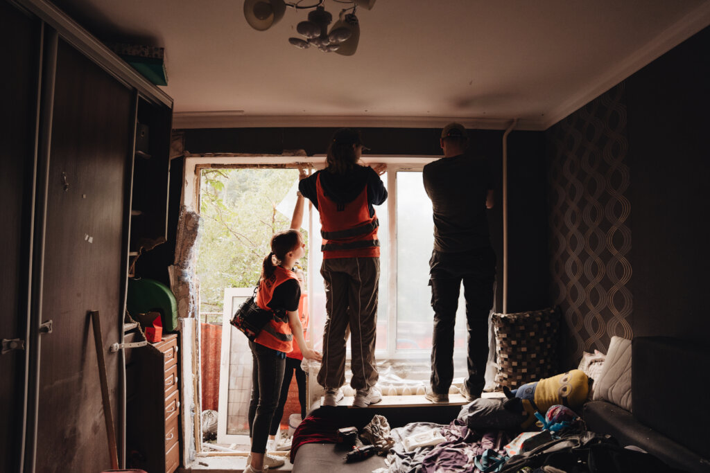 Volunteers Securing Shattered Window After Attack