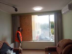 Volunteer Securing a Living Room Window