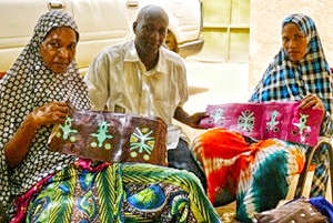 Illia working on handbags with artisans.