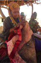 Inaden artisan Tibilan Ana sewing an adefur pillow