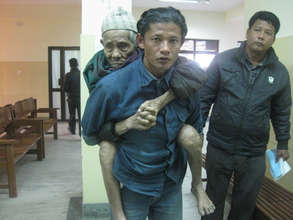 A patient is carried to an outreach in Nepal