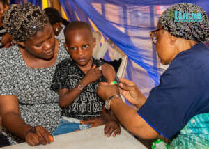 Health volunteer checks child's nutrition status