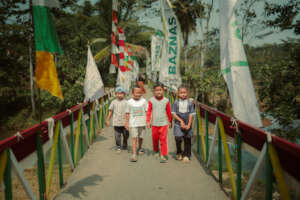 Children cross the new bridge in their village