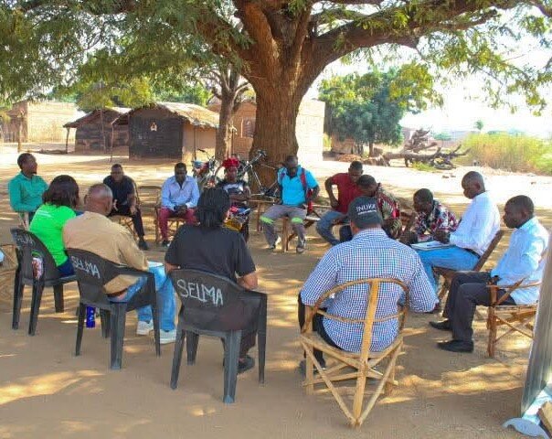 Community dialogue in Peace Circle under tree