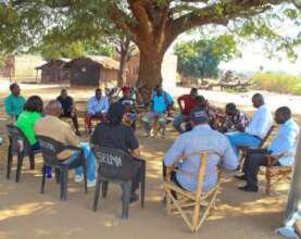 Community dialogue in Peace Circle under tree