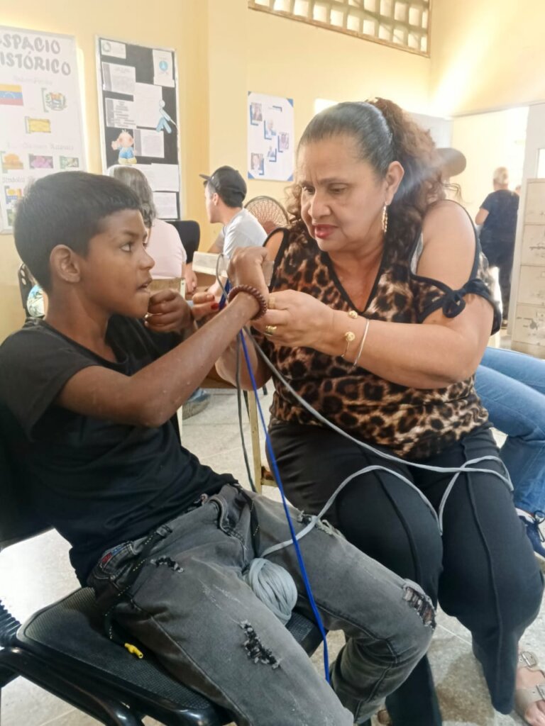 Lead knitter teaching a visually impaired child ho