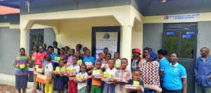 CHILDREN POSE IN A PHTO AFTER RECEIVING THE ITEMS.