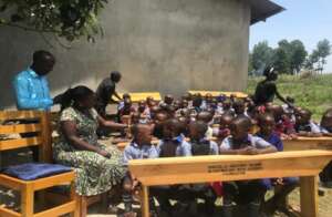 Teachers and pupils enjoying their new desks