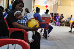 Mother and daughter wait to be seen at the clinic.