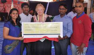 CHI graduates present a check to Christel DeHaan